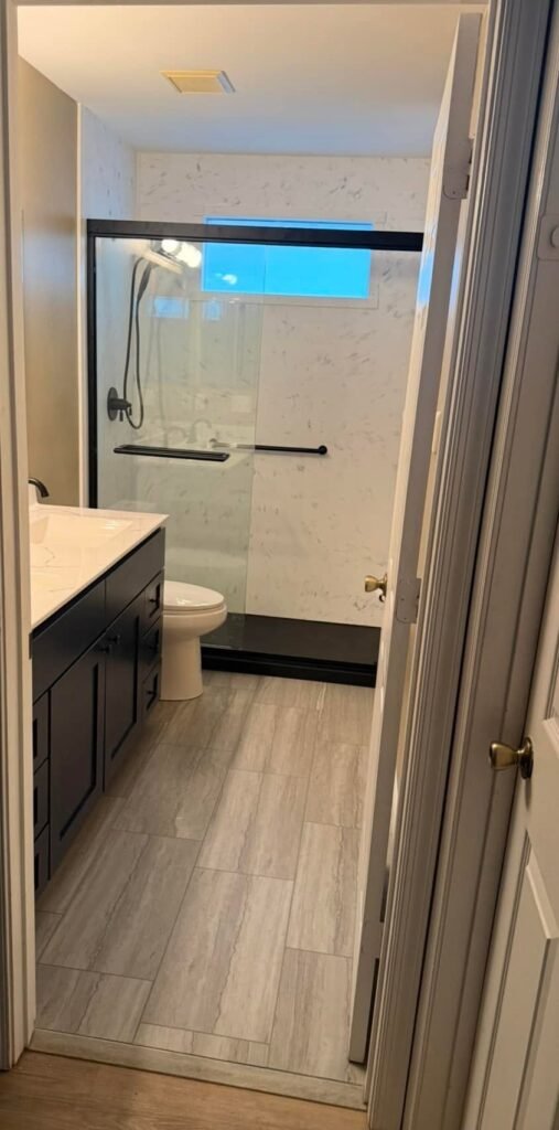 After: new walk-in shower, dark vanity and wood-look floor