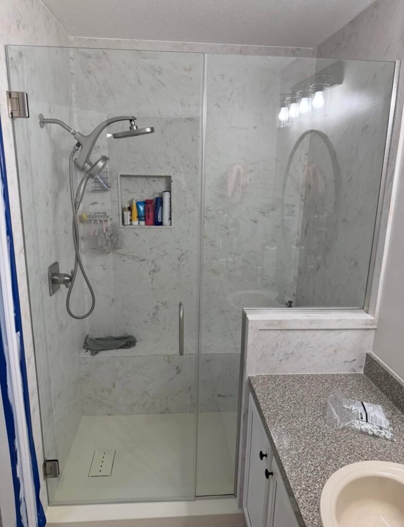 After: walk-in shower with frameless glass, niche and handheld shower
