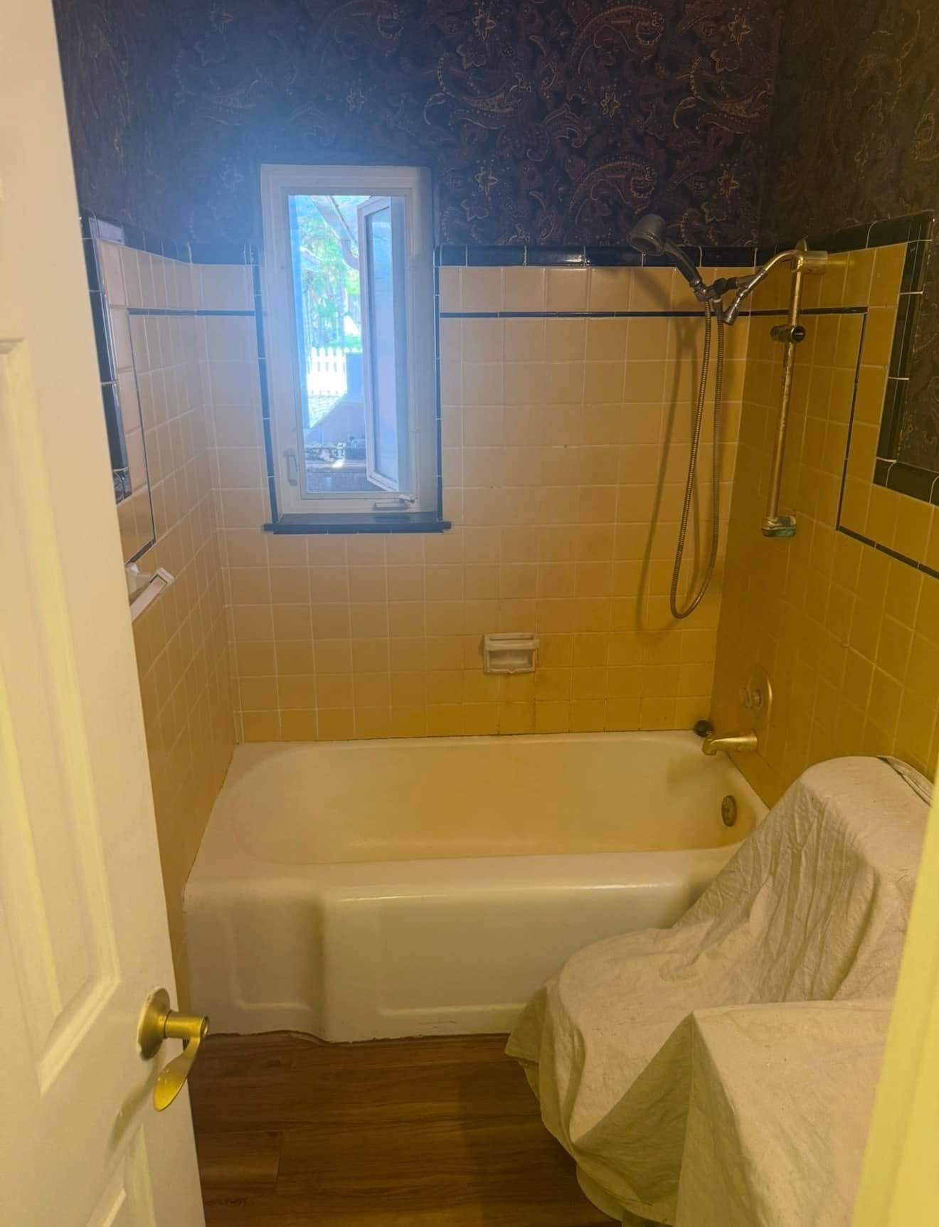 Before: a tub and shower combination with a curtain